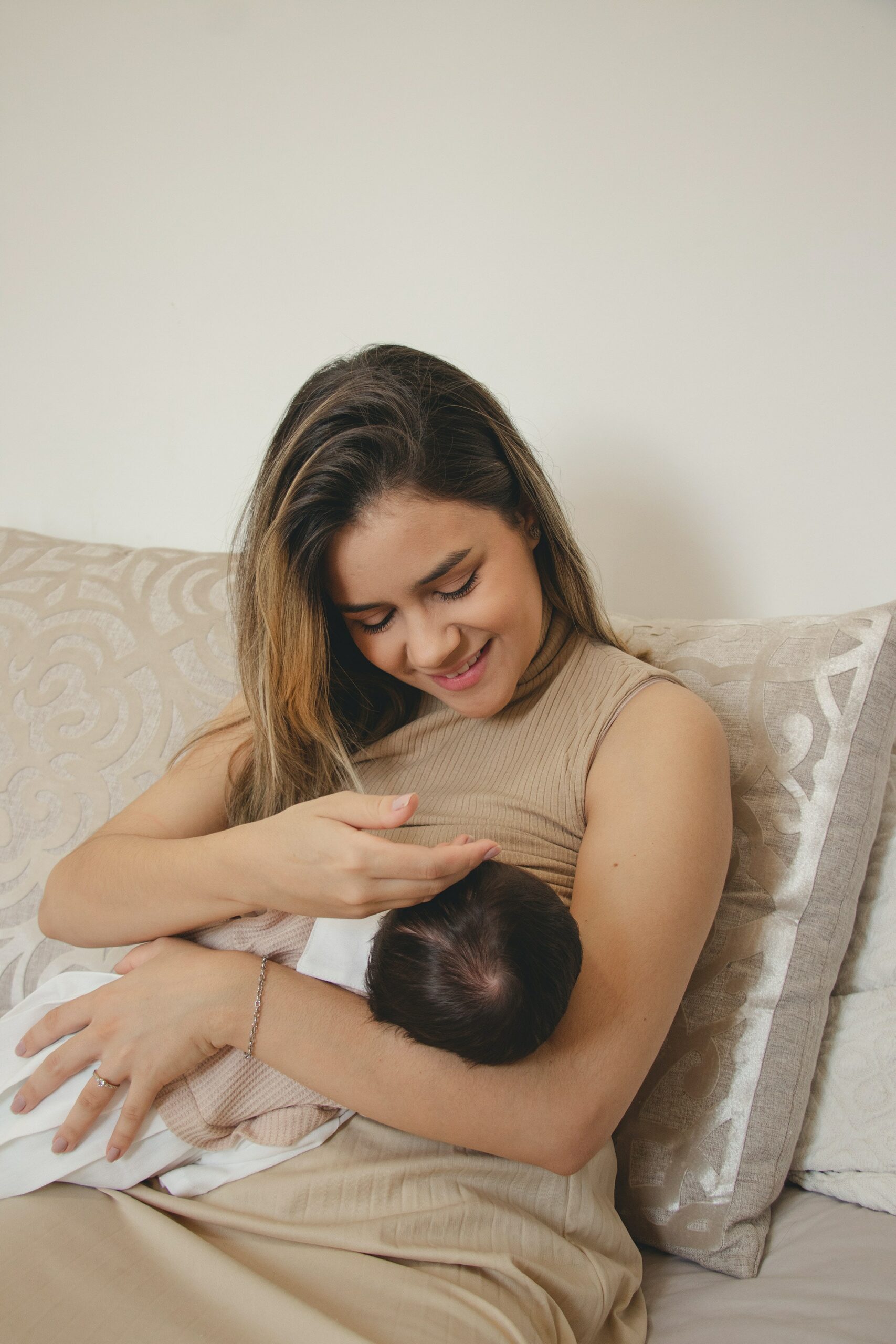 https://www.pexels.com/photo/a-mother-sitting-on-the-couch-while-breastfeeding-her-baby-14585081/